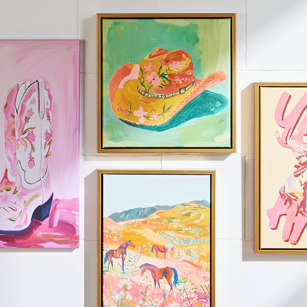 A gallery wall of four framed art prints featuring Western-themed illustrations
