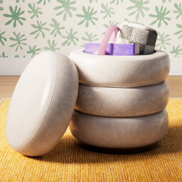 Light beige, tire-shaped storage ottoman with a removable lid, sitting on a yell